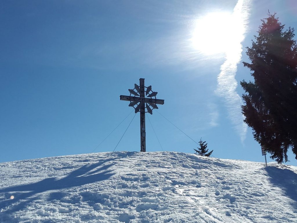 Gipfelkreuz auf verschneitem Allgäuer Berg